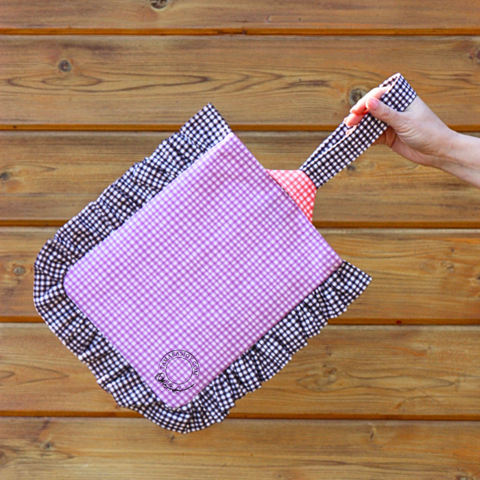 ruffle bag being swung outwards in front of a fence
