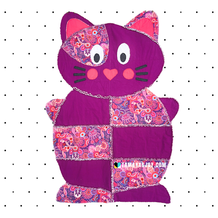 Purple cat-shaped rag quilt with floral patterns on a white background