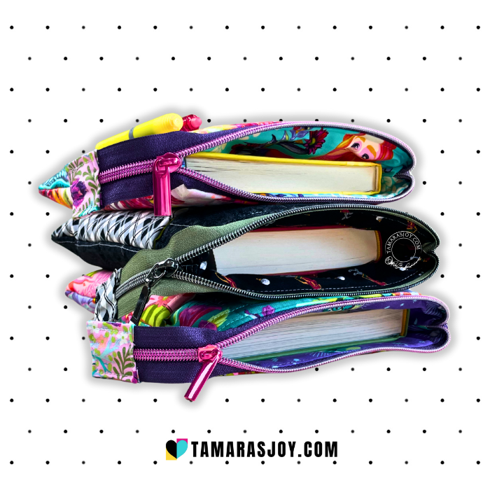 3 Colorful book pouches stacked including pens and notebooks on a white background with black dots, branded 'TamarasJoy'.