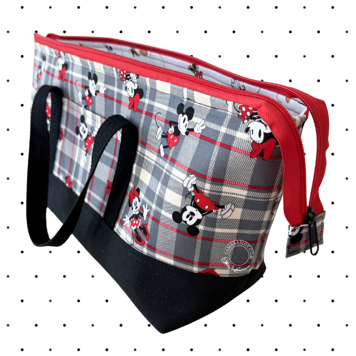 A Disney-themed zippered tote bag featuring a gray and white plaid pattern with Mickey and Minnie Mouse prints, red trim, black handles, and a black base, shown on a white background with a black polka dot pattern.